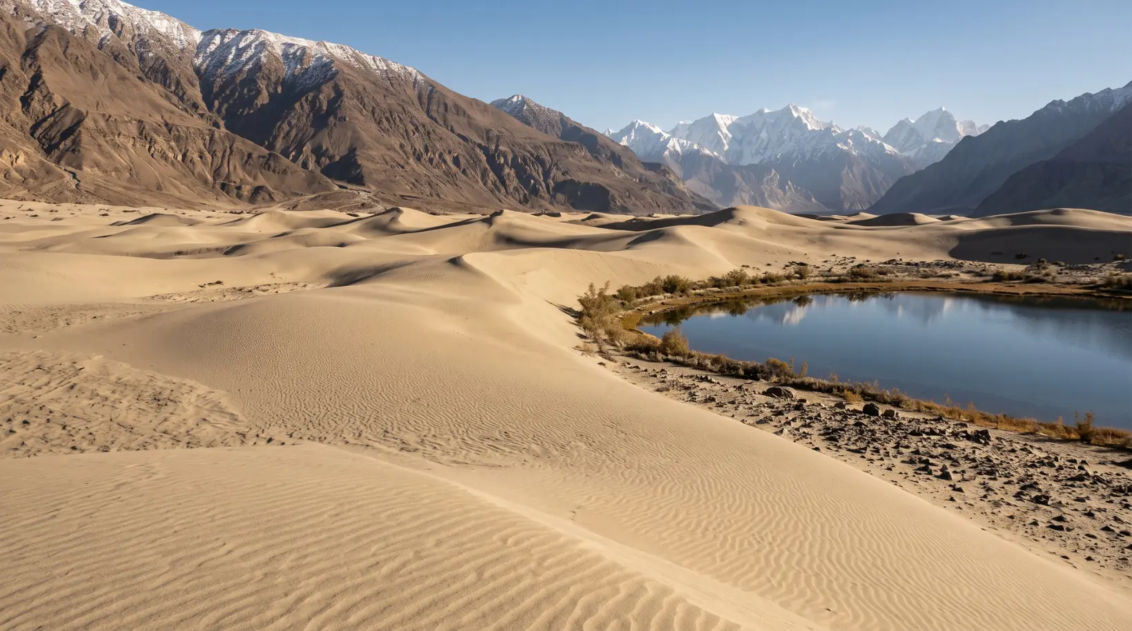 Katpana Desert golden dunes and Katpana Lake near Skardu, Gilgit Baltistan